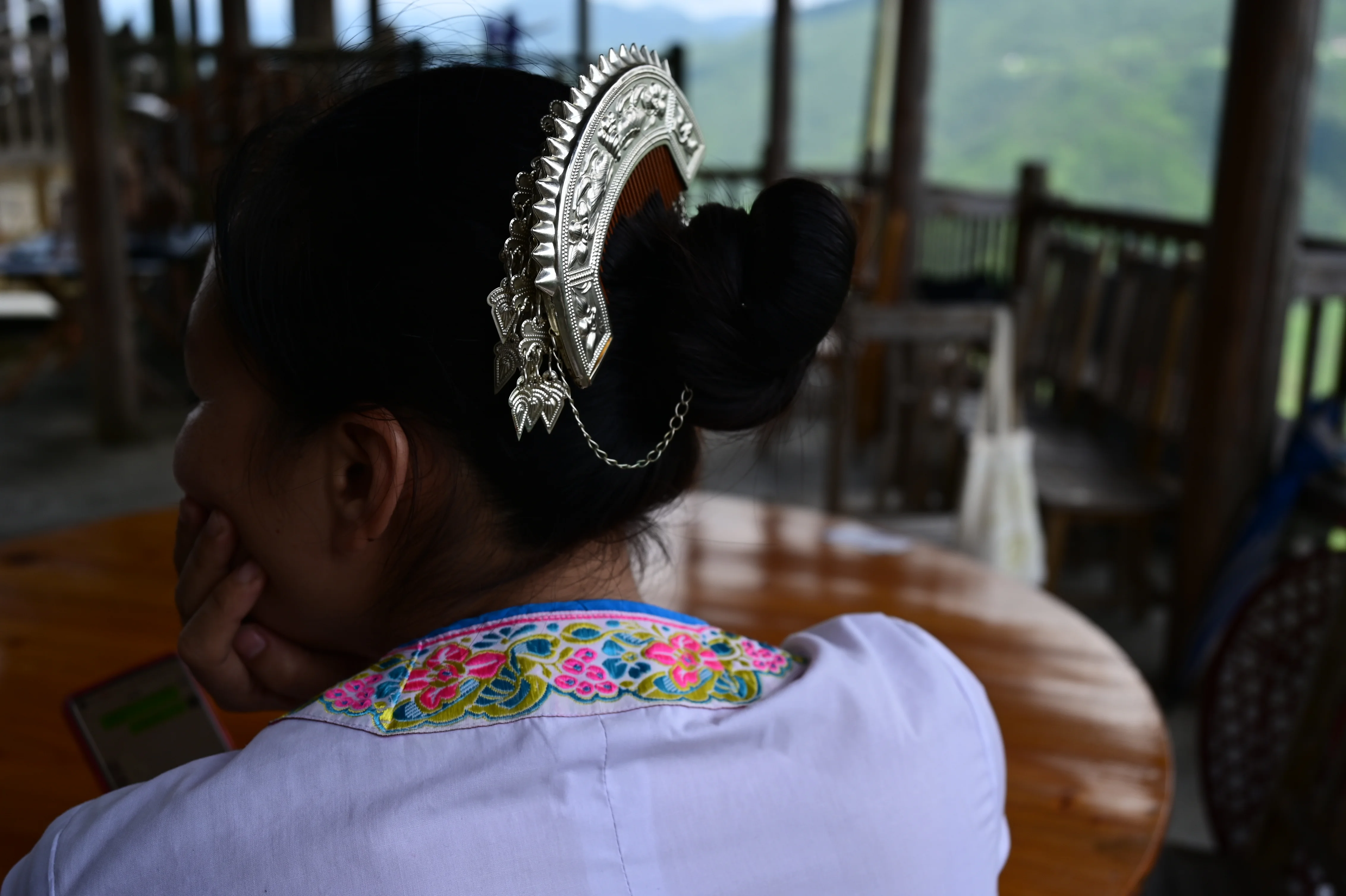 Panoramic view of a hillside minority village nestled among green mountains in rural Guangxi, China